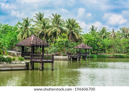 Beautiful riverside landscape with palm trees and resting pavilion in Thailand