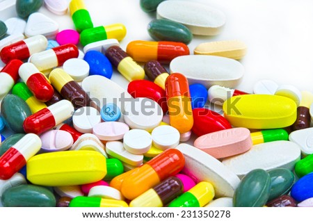 Pile of colorful drugs pills capsules and medicine for health care industry in white isolated background