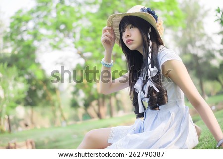 A cute Asian Thai girl is looking in the sky with hope in natural atmosphere with soft focus.