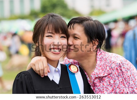 Mother is kissing her daughter with joy for her master degree graduation in Thailand university