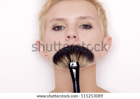 Attractive blonde Make-up artist holding brushes