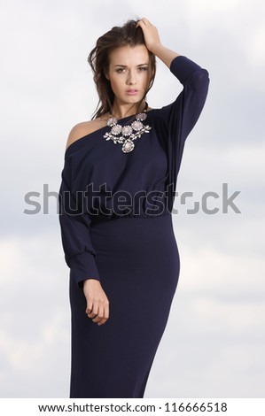 Sexy brunette woman posing in violet dress.