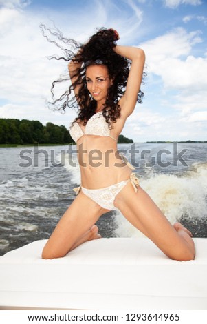 Beauty brunette woman posing on the boat