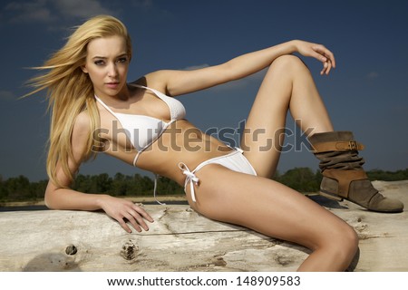 beautiful blonde woman in white bikini on the beach