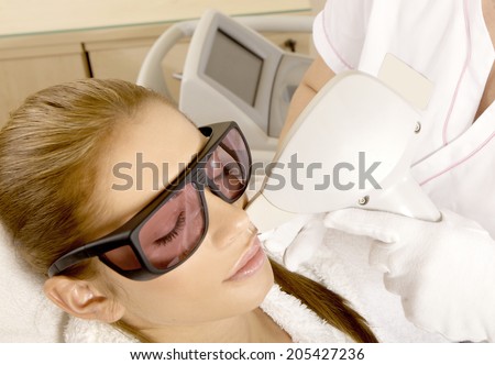 Laser hair removal in professional studio. Beautiful brunette woman.
