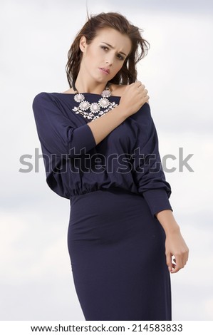 Young adult attractive sexy and sensuality brunette woman posing in violet dress on the sand