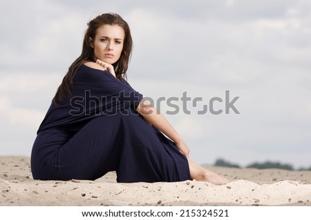 Sexy and sensuality attractive young adult brunette woman posing in violet dress.