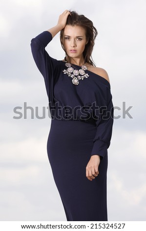 Sexy and sensuality attractive young adult brunette woman posing in violet dress.