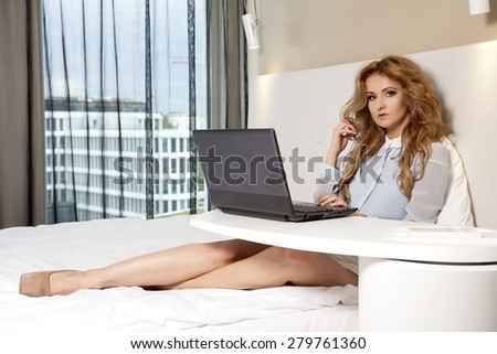 Young adult beauty attractive sexy and sensuality happy pretty blonde businesswoman using laptop while lying on bed in hotel room