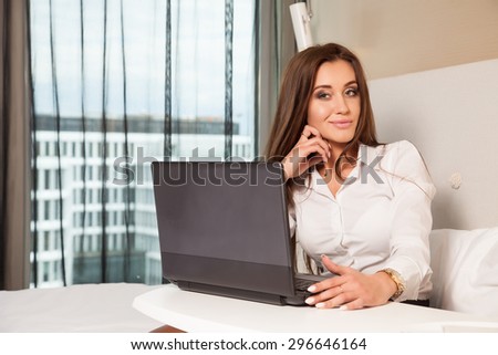 Young adult beauty attractive sexy and sensuality happy pretty brunette businesswoman using laptop while lying on bed in hotel room