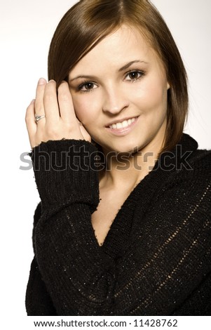 beautiful brunette wearing black sweater on light background