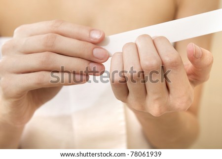 Body-care of hands. Woman polishing fingernails with the nail file