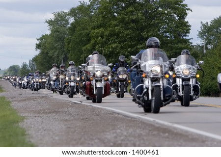 long line of motorcycles on country road