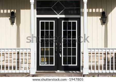 Double French doors with porch, pale yellow siding and white trim
