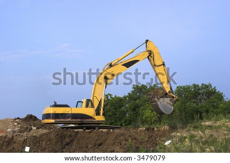 Large yellow and black excavator scooping dirt at a construction site