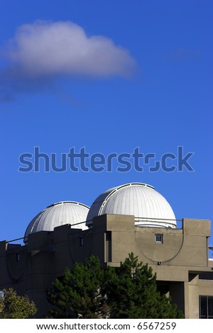 Twin astral observatories atop a building. Vertical format with copyspace .