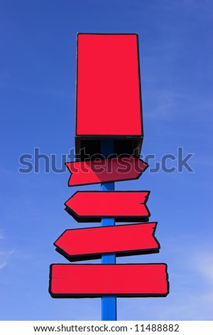 Red directional signpost against a blue sky. Place your signs/logos.