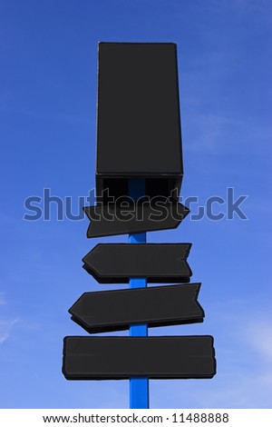 Black directional signpost against a blue sky. Place your signs/logos.