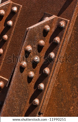 Structural details of a rusty steel cantilever bridge.