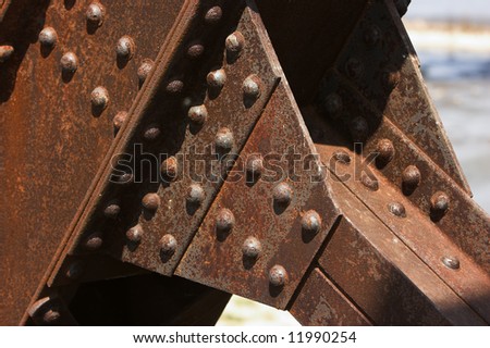 Structural details of a rusty steel cantilever bridge.