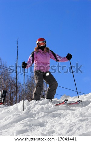 Woman standing at the top of a ski hill.