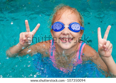 little girl in the pool in a victory pose