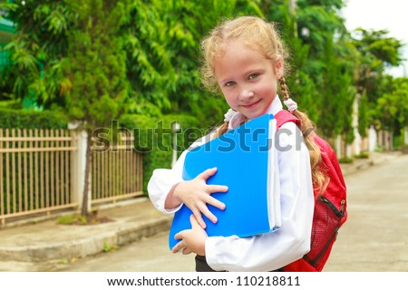 A young little girl preparing to walk to school