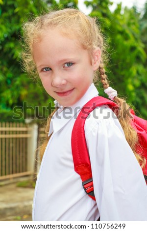 A young little girl preparing to walk to school