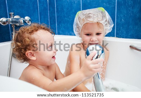 little brother and sister taking a relaxing bath with foam