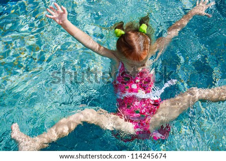 Girl jumps into the water in the pool