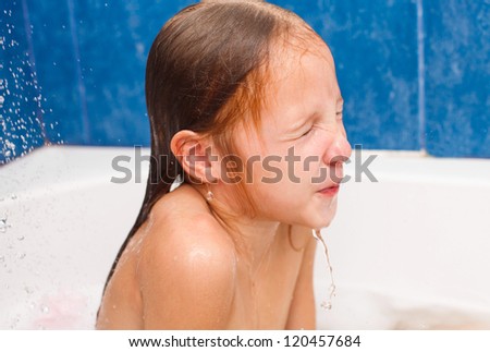 Cute eight year old girl taking a relaxing bath with foam. The symbol of purity and hygiene education.