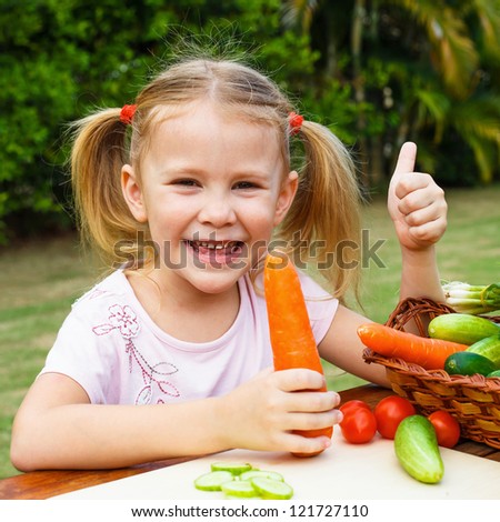 happy girl shows gesture cool and  holding a carrots. Concept of healthy food.