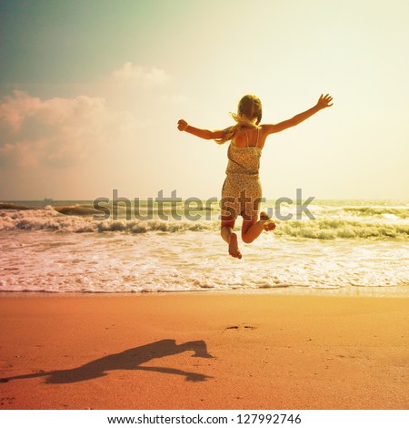 Happy Girl Jumping On The Beach On The Dawn Time