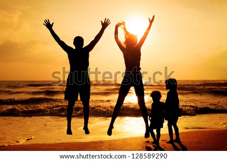 Happy Family Jumping On The Beach On The Dawn Time
