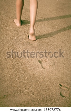Beautiful young girl  legs, walking on the beach