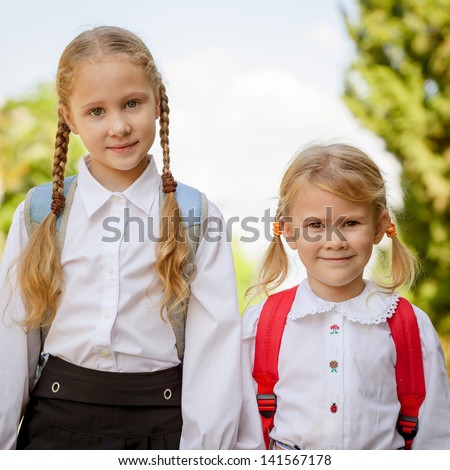 two young little girls preparing to walk to school