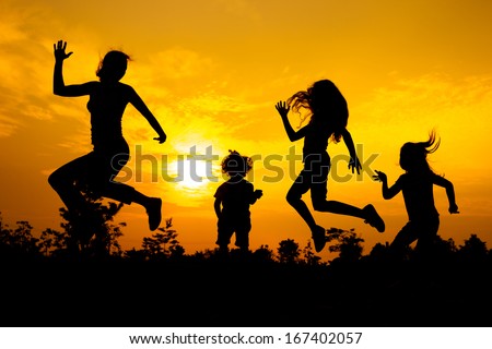 Happy  family dancing on the  road in the  sunset time.