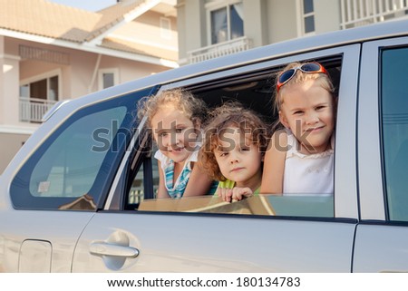 three happy kids sitting in the car three happy kids sitting in the car
