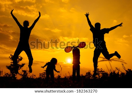 Happy family playing with balloons on the road in the sunset time. Evening party on the nature