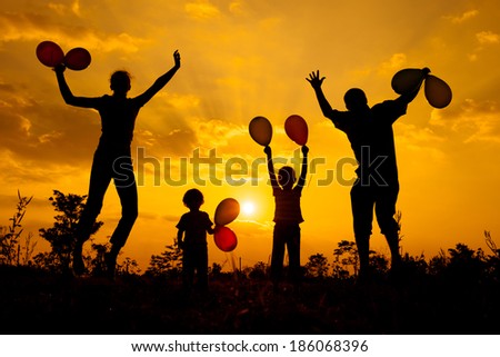 Happy  family playing with balloons on the  road in the  sunset time. Evening party on the nature