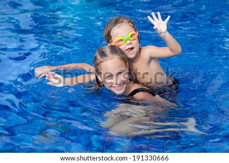 brother and sister playing in the swimming pool