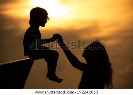 mother and  son playing on the beach in dawn time