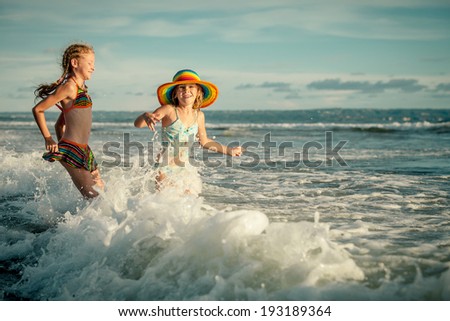two sisters splashing on the beach in the day time