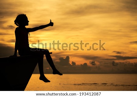 happy teen girl sitting on beach at the dawn time