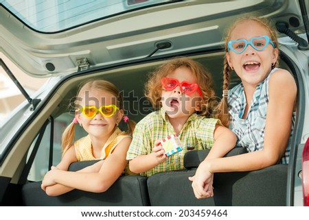 Brother and sisters  sitting in the car at the day time