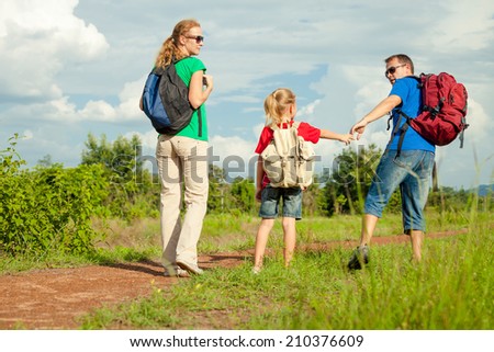 Happy family walking on the road at the day time. Concept of friendly family.