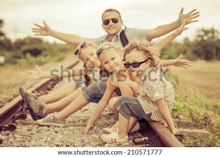 Happy family sitting on the railway at the day time. Concept of friendly family.