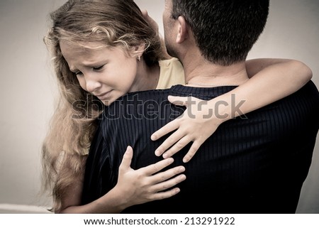portrait of one sad daughter hugging his father