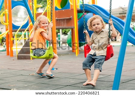 Two happy children playing on the playground at the day time. Concept brother and sister forever.