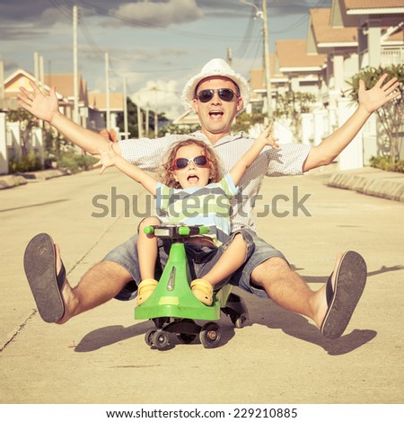 father and little son playing near a house at the day time